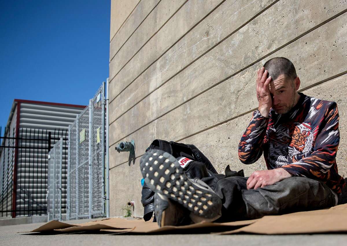 Tyson Feilzer, 40, sits on a cardboard box along Bryant Street near Main Street along the Embarcadero in San Francisco, Calif. Sunday, April 7, 2019.