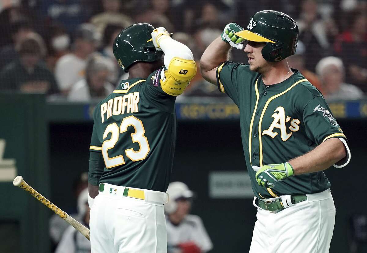 Oakland Athletics' Stephen Piscotty, right, celebrates with teammate Jurickson Profar (23) after hitting a solo home run off Nippon Ham Fighters starter Yuki Saito in the second inning of their pre-season exhibition baseball game at Tokyo Dome in Tokyo Monday, March 18, 2019. (AP Photo/Eugene Hoshiko)