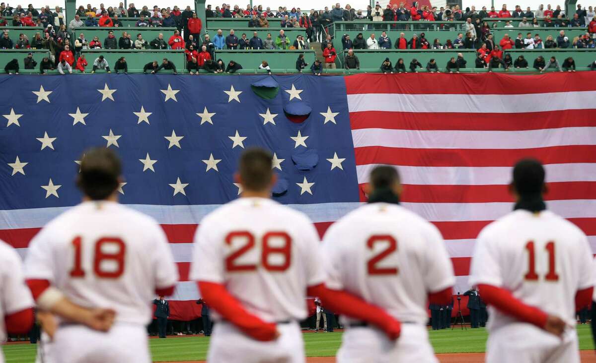 The Boston Red Sox stand for the national anthem before their home opener against the Toronto Blue Jays at Fenway Park Tuesday.