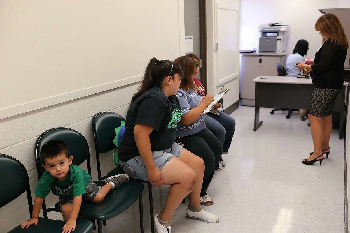 Noel Medina, then 2, played as his mother, Leticia Medina, 45, filled out an application at Bexar County's first school-based health center at Collier Elementary School in Harlandale ISD in 2013. The same kind of partnership with University Health System will see San Antonio ISD open clinics at two of its middle schools.