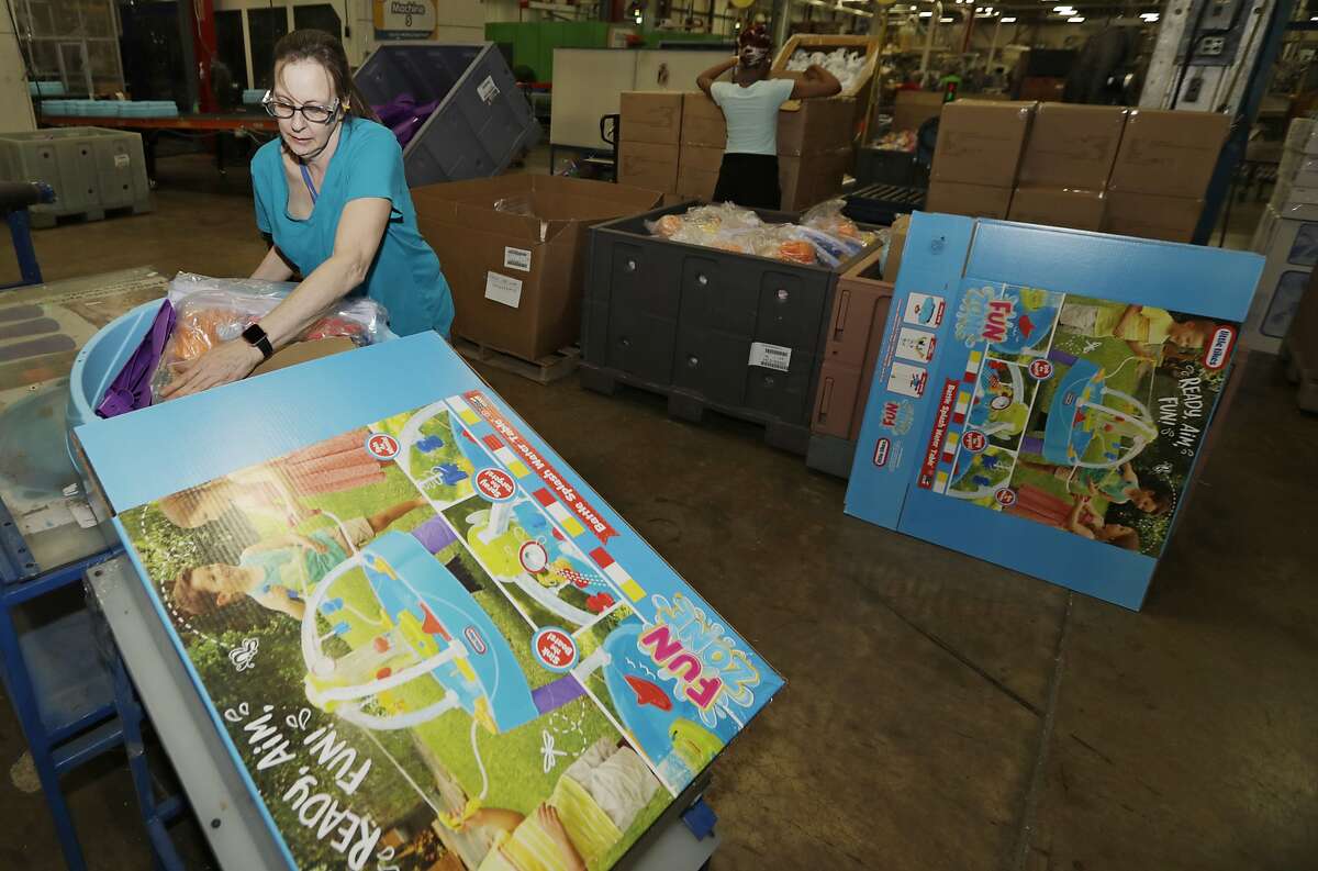 In this Thursday, March 28, 2019, photo Kelly Schubert loads a Battle Splash Water Tank into a box at the The Little Tikes Company in Hudson, Ohio. A year after Toys R Us imploded, toy makers, big and small, are still readjusting to smaller shelf space. That means slashing the number of styles they carry, re-evaluating how they sell big toys like playhouses and cars, and changing their packaging in order to squeeze into a smaller space at retailers. (AP Photo/Tony Dejak)