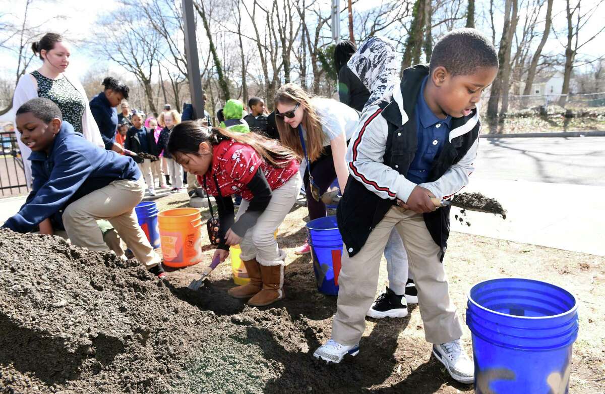 First-grader Wesley McBride, right, fills a bucket of dirt for a raised-bed garden in front of Beecher School in New Haven as part of Outdoor Day organized by Connecticut Schoolyards program manager Suzannah Holsenback on April 10, 2019.