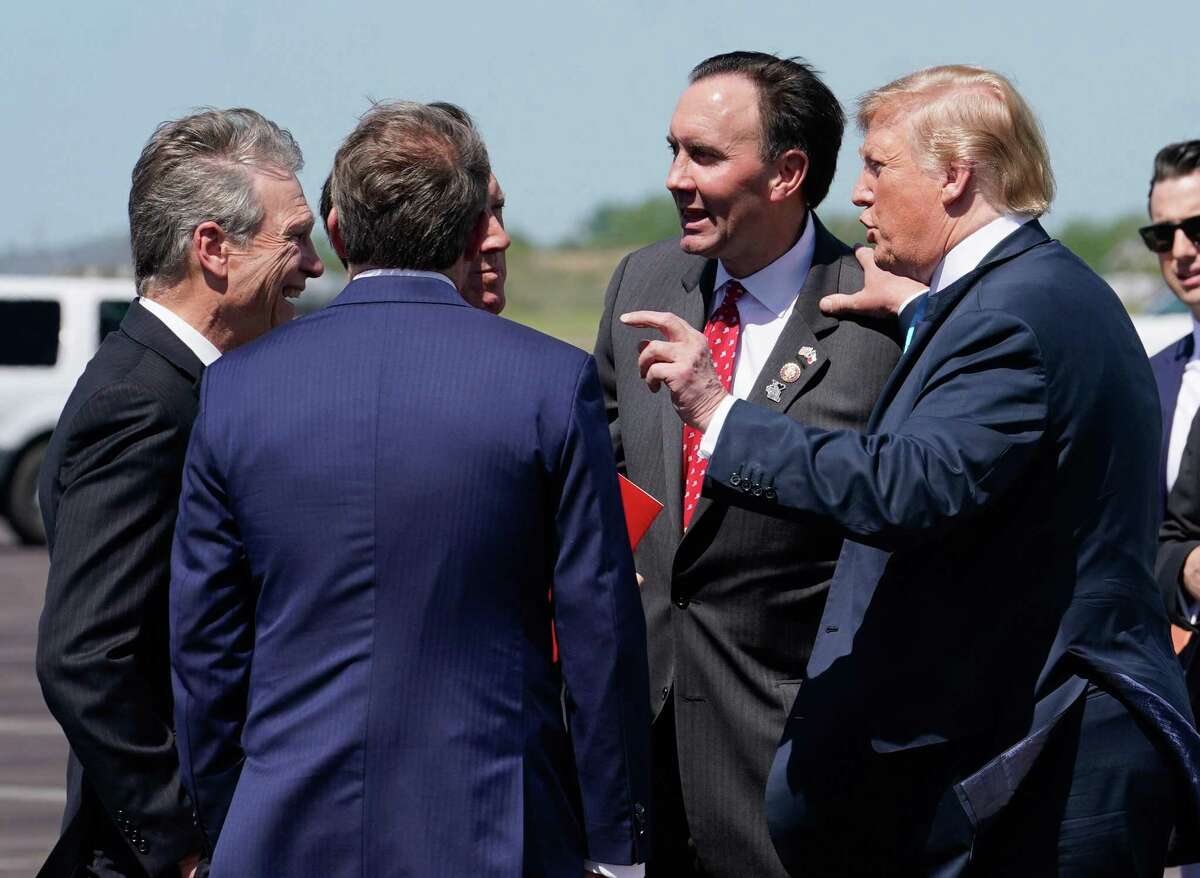 U.S. Rep. Pete Olson, second from right, and others greet President Donald Trump at Ellington Field on Wednesday, April 10, 2019, in Houston.