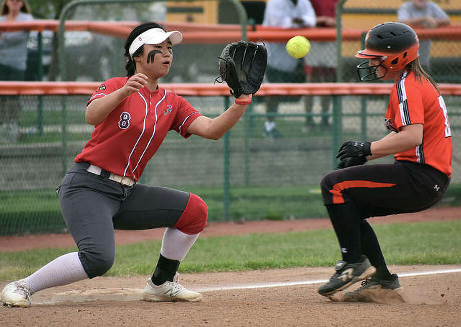 Edwardsville’s Sydney Lawrence (right) scampers into third base to beat the throw to Alton shortstop Tami Wong on Wednesday at the District 7 Sports Complex in Edwardsville. Photo: Matt Kamp / Hearst Illinois