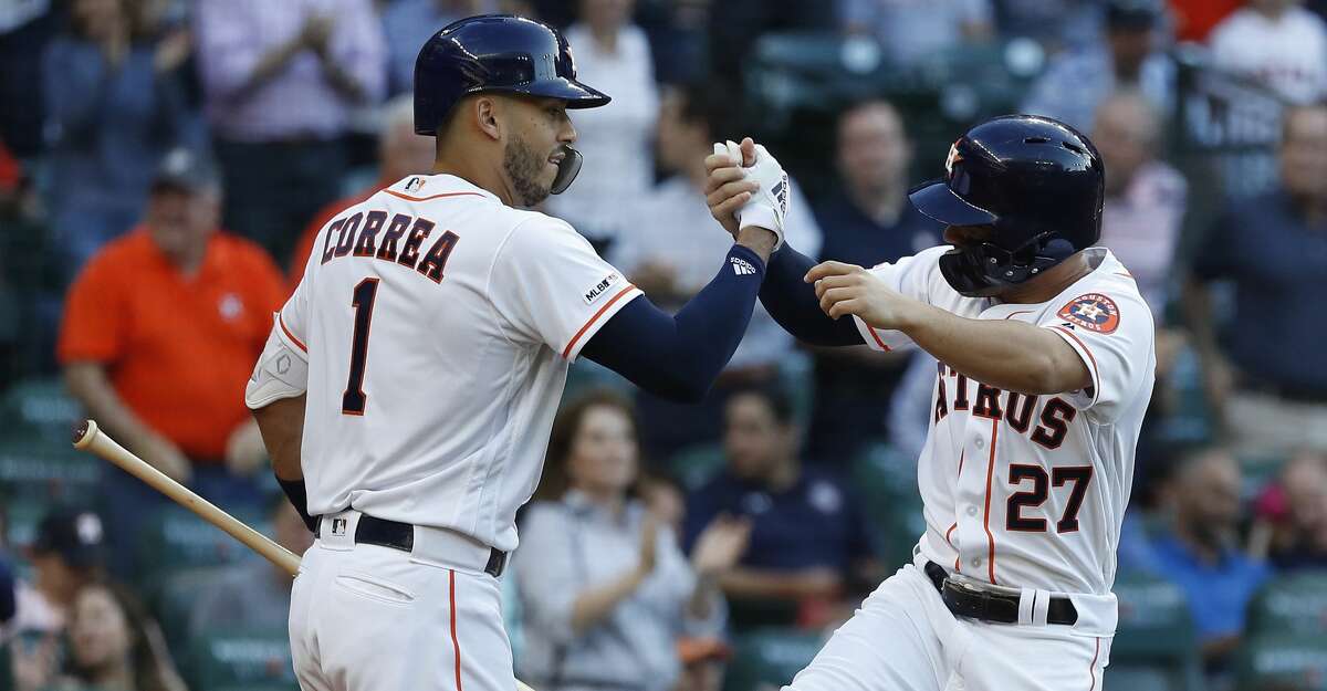 Houston Astros Jose Altuve (27) celebrates his home run with Carlos Correa (1) during the first inning of an MLB game at Minute Maid Park, Wednesday, April 10, 2019, in Houston.