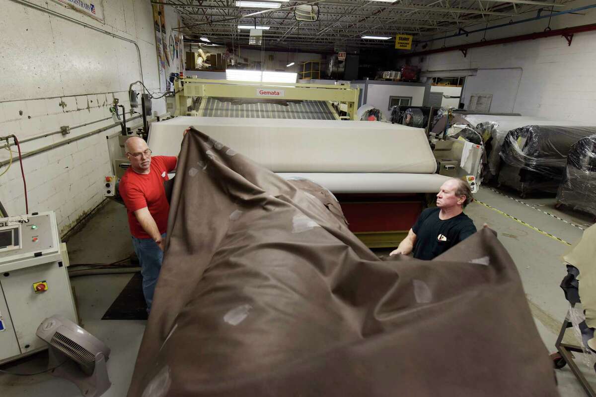 Employees, Oakley Cole, left, and Bill Mouck pull a large piece of leather to feed it into a machine that will soften the material at Townsend Leather on Monday, March 5, 2018, in Johnstown, N.Y. (Paul Buckowski/Times Union)