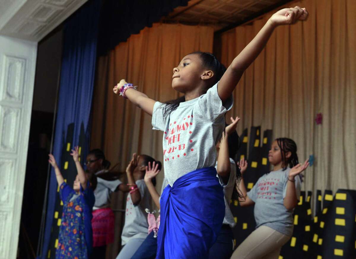 Fourth grade student Naomi Maxwell dances during a Bollywood version of "One World" as Hall School celebrates 100 years with a broadway review performed by students Friday, Nov. 22, 2013 at the school in Bridgeport, Conn.