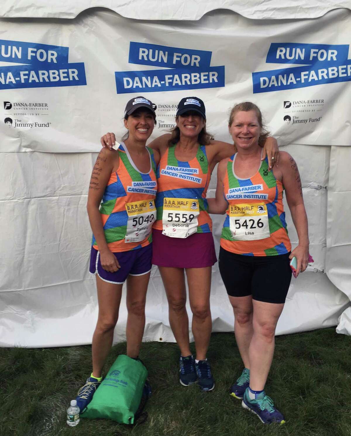 From left to right, Pamela Karpen, her sister, Deborah Sloan, and their friend, Lisa Singer. Written on their arms are the names of family and friends who had cancer that the trio runs for.