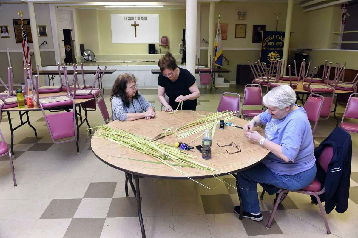 In New Haven, from left, Kathy Heimann of West Haven gets instructions from Peggy Cummings of East Haven for making palm crosses as Kathy Vissicchio of East Haven works on others in the basement of St. Michael Church in New Haven on April 11, 2019. This is the third year that volunteers under the direction of Jean Quartiano have made palm crosses for parishioners of the church for Palm Sunday.
