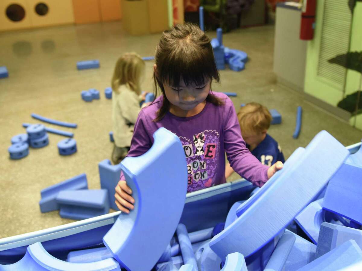 Greenwich's Yuka Ogawa, 6, looks through a bin of Imagination Playground blocks to find just the right shape during Fall Family Day at the Bruce Museum in Greenwich, Conn. Sunday, Oct. 14, 2018. Students used the lightweight foam blocks to build their own imaginary objects and also completed specific challenges to build the blocks into a tower, flower, car and more.