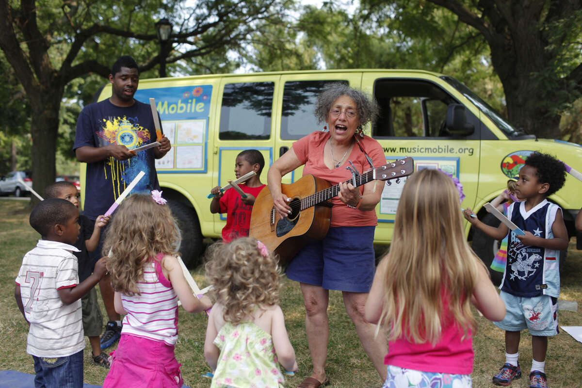 Ruth Pelham, founder of the Music Mobile, leads children in song while they play their "peace wand" instruments in Washington Park, Friday afternoon July 13, 2012, in Albany, N.Y. (Dan Little / Special to the Times Union)