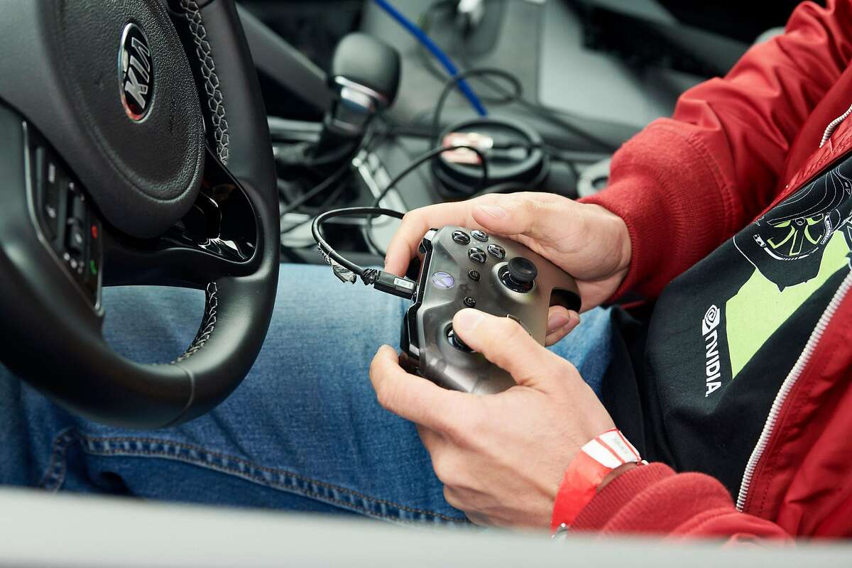A car hacker with an Xbox controller, which is often used to calibrate and test steering, acceleration and brakes before turning controls over to software, during Self Racing Cars, an annual open-track event for autonomous vehicles, in Willows, Calif., March 23, 2019. A racetrack veteran compares the Self Racing Cars contest to hot-rod modders of old: “This event, with its hackers, tinkerers and engineers, is just like that.” (Aaron Wojack/The New York Times)