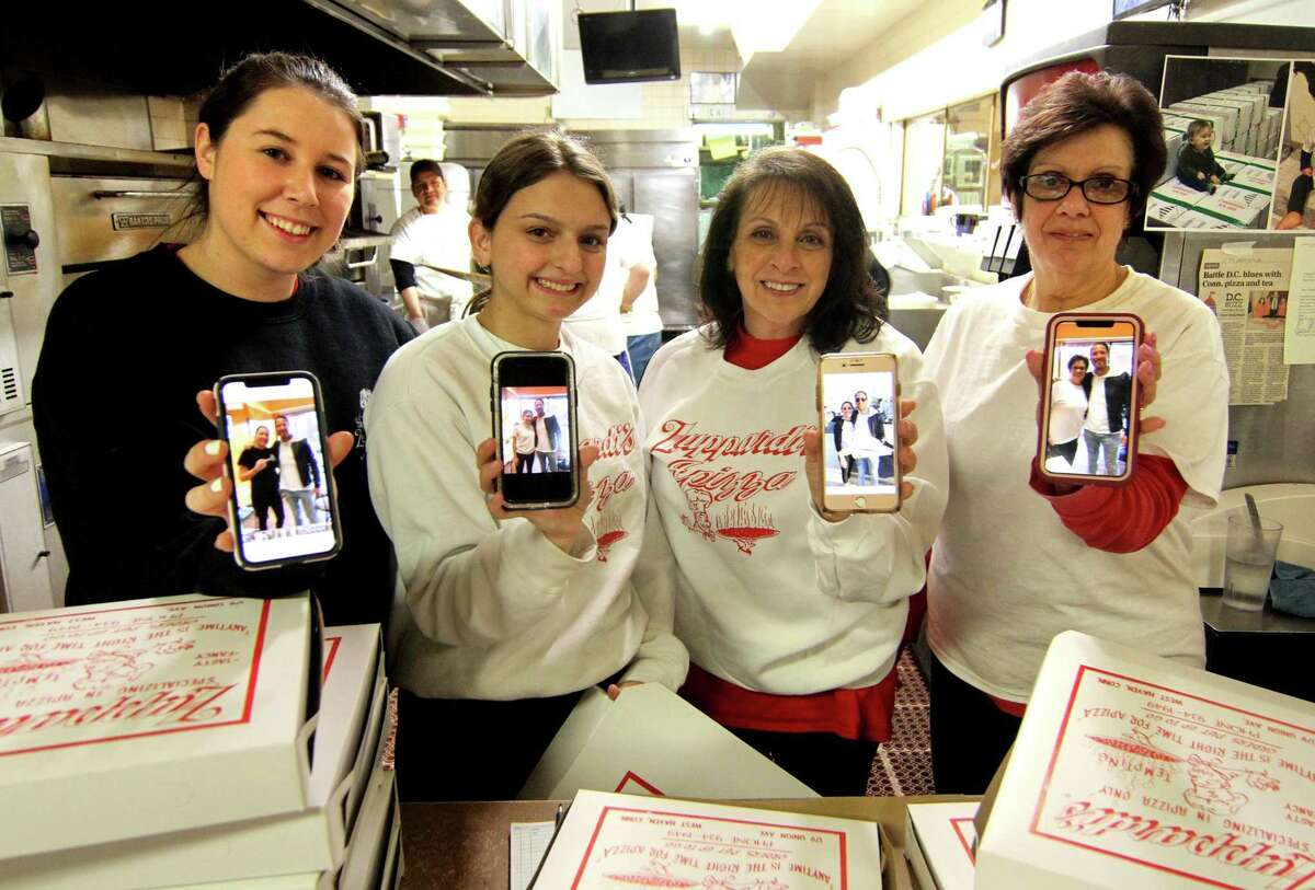 Some of the staff of Zuppardi's Apizza hold up their phones with photos of Davind Portnoy at the restaurant in West Haven, Conn., on Wednesday April 10, 2019. From left to right is Meagan Bickelhaupt, Ashley Rossi, Lori Zuppardi and her sister Cheryl Zuppardi-Pearce. The famous barstool reviewer David Portnoy popped in o. The legendary Zuppardi's Apizza last week, giving it a thumbs up and wore his Zuppardi's sweatshirt to the final four.