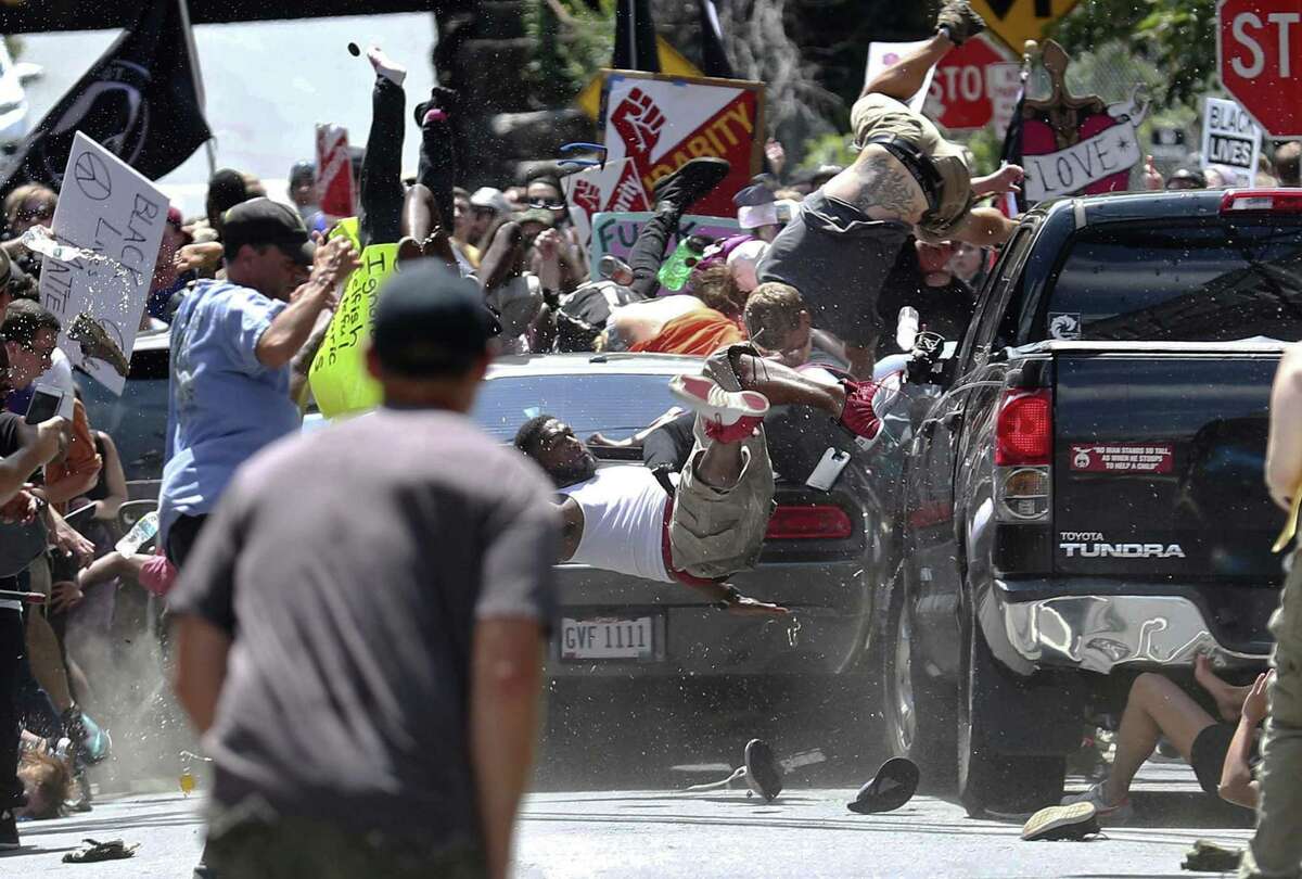 In this 2017 file photo, people fly into the air as a vehicle is driven into a group of protesters demonstrating against a white nationalist rally in Charlottesville, Va.