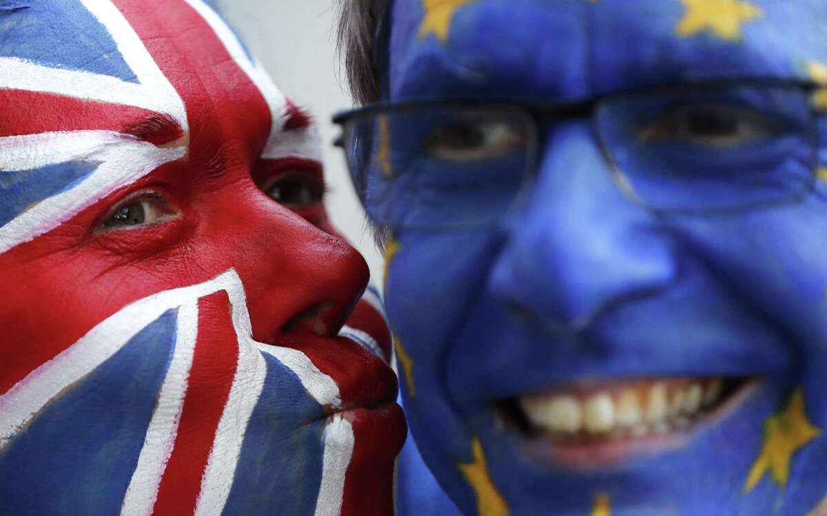Activists pose March 21 with their faces painted in the EU and Union Flag colors during an anti-Brexit campaign stunt outside EU headquarters during an EU summit in Brussels. The country's struggle to leave the European Union is one of the great political crisis to afflict Britain in the postwar period.