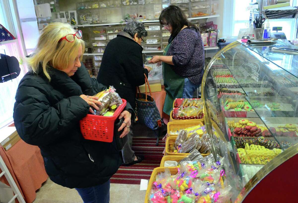 Customer Lynda Chaco tries to keep items from falling out of her basket as she waits to make a purchase at Tidmarsh’s Home Bake Shop in Ansonia Friday.