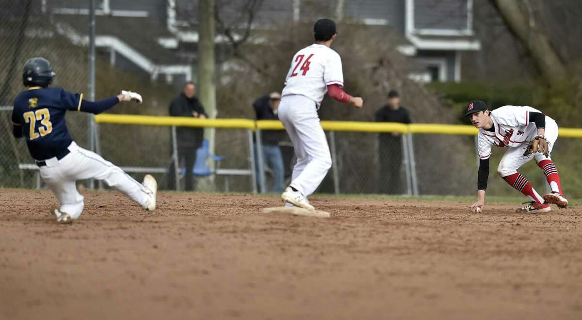 East Haven’s Giro Esposito slides into second base as Anthony Burzynski of Branford, center, waits for a throw from teammate Jake Bodner on Friday.