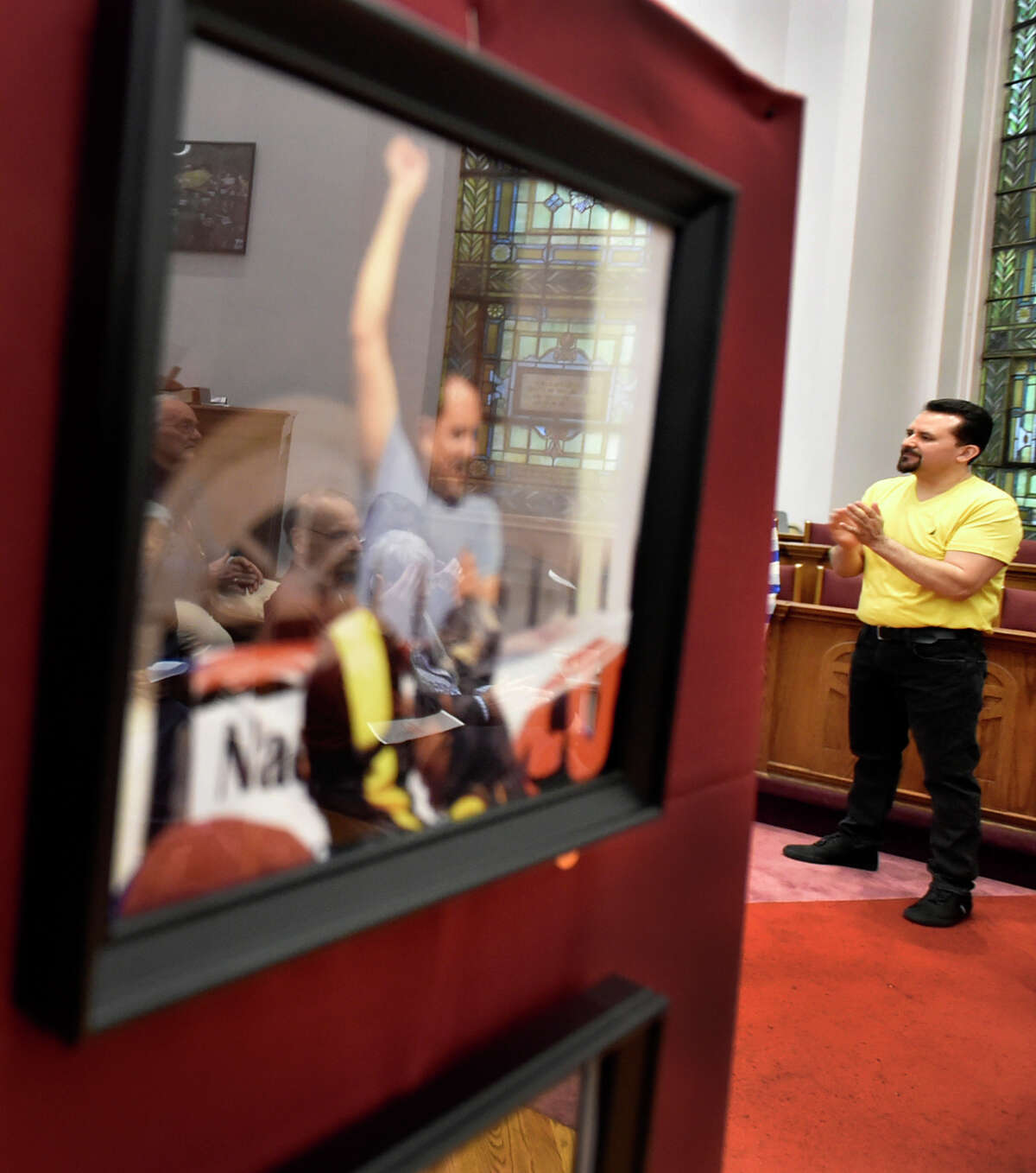 New Haven, Connecticut - Saturday, April 13, 2019: Nelson Pinos, an undocumented immigrant from Ecuador facing deportation, with his 500th day in sanctuary Saturday at the First and Summerfield Church in New Haven listens to a speaker during the opening of a photographic exhibition fundraising event Saturday evening for him and his family at the church.The photo exhibit documents Pinos, in sanctuary in New Haven since November 30, 2017, and Sujitno Sajuti, in sanctuary in Meriden since October 10. 2017. Pinos, a resident of New Haven, has lived in the U.S. since 1992. He is married and the father of three American citizen children