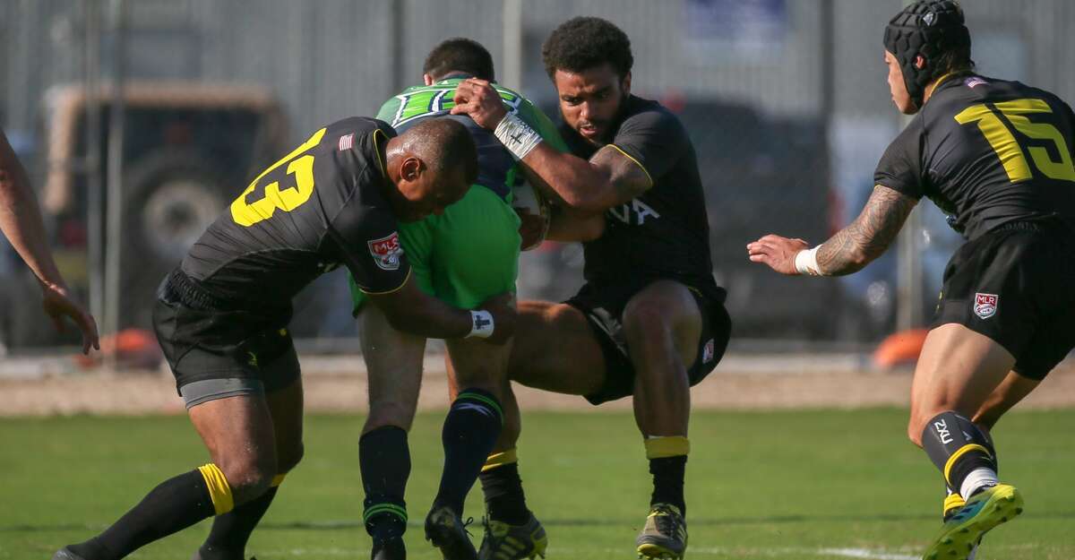 April 13, 2019: Houston SaberCats center Osea Kolinisau (13) and Houston SaberCats wing Deion Mikesell (14) tackle Seattle Seawolvesfullback Matthew Turner (15) during the Major League Rugby match between the Seattle Seawolves and Houston SaberCats at Aveva Stadium in Houston, Texas.