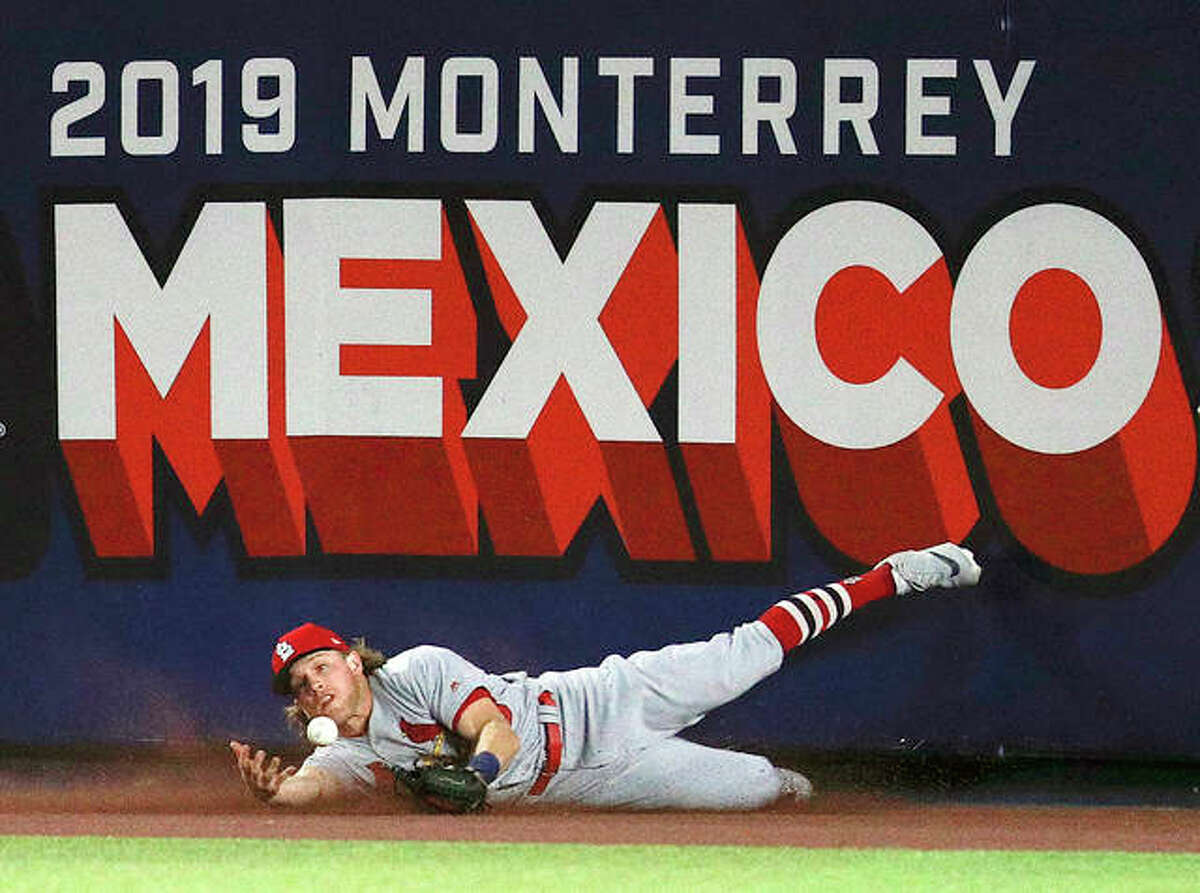 The Cardinals’ Harrison Bader can’t make the catch on a triple by Cincinnati’s Phillip Ervin in the eighth inning of Saturday night’s game in Monterrey, Mexico. The Reds defeated the Cardinals 5-2.