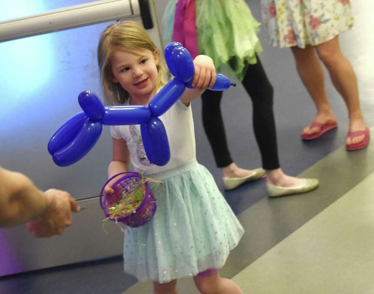 Stamford's Elizabeth Harnisch enjoys her blue balloon dog at the Bunny Hop children's event at Chelsea Piers in Stamford, Conn. Sunday, April 14, 2019. The event featured face painting, cotton candy, coloring, balloon animals, food and drinks, Easter baskets with candy, and a special appearance by the Easter Bunny.