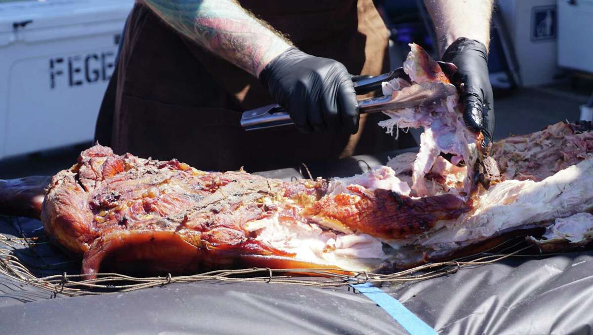 Patrick Feges of Feges BBQ works into the hog that has been cooked between 12 to 15 hours at the 7th Annual Houston Barbecue Festival on April 14 in Humble.