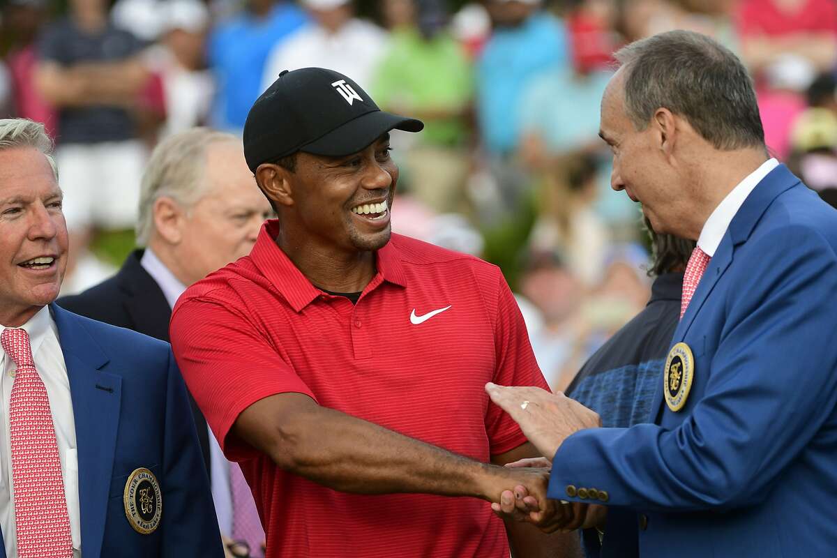 FILE - In this Sept. 23, 2018, file photo, Tiger Woods, center, is congratulated after winning the Tour Championship golf tournament in Atlanta. It was his first victory in more than five years, dating to the 2013 Bridgestone Invitational. Woods completes an amazing journey by winning the 2019 Masters, overcoming 11 years of personal foibles and professional pain that seemed likely to be his lasting legacy. (AP Photo/John Amis, File)