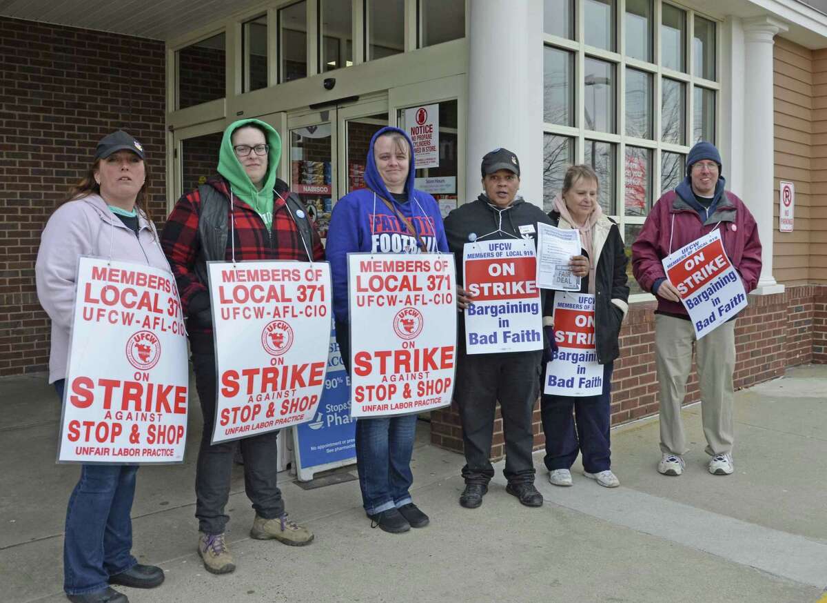 Striking employees hold signs outside of the Silver Sands Stop & Shop in Milford, Conn., Thursday, April 11, when they walked off their jobs in a battle for benefits, wages and more.