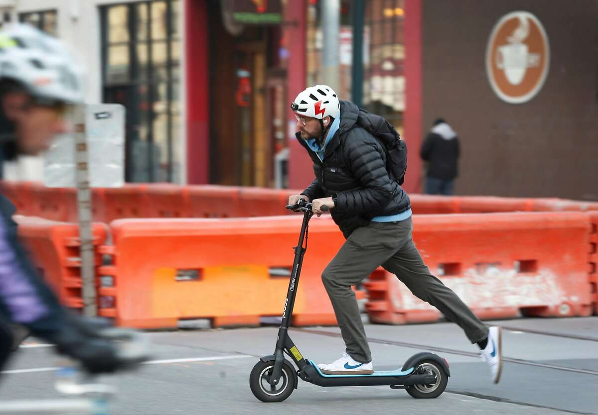 A commuter rides an e-scooter on Townsend Street in San Francisco, Calif. on Tuesday, March 19, 2019.