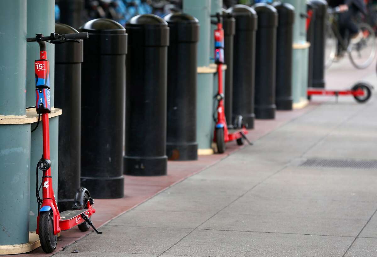 Scoot e-scooters are parked at the Caltrain station on Townsend Street in San Francisco, Calif. on Tuesday, March 19, 2019.