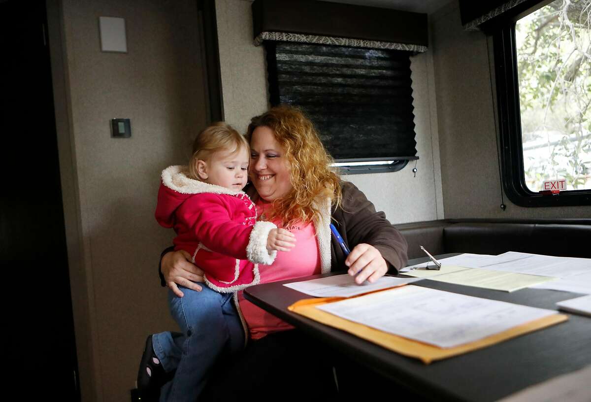 Camp fire survivors, two-year-old Charlotte Sherwood and her mom Marianne Warner finish the paperwork, inside their trailer, as they move into the Bidwell Canyon State Campground on the shore of Lake Oroville, as seen on Mon. April. 15, 2019, in Oroville, Ca. FEMA has installed 69 trailers at the campground for Camp Fire survivors to use.
