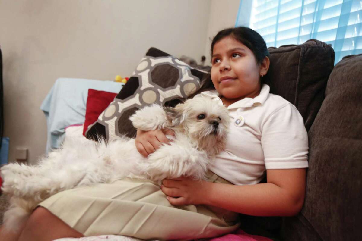 Laura Maradiaga, 11, holds her dog , Lalo, Thursday, April 11, 2019, in her Houston home.