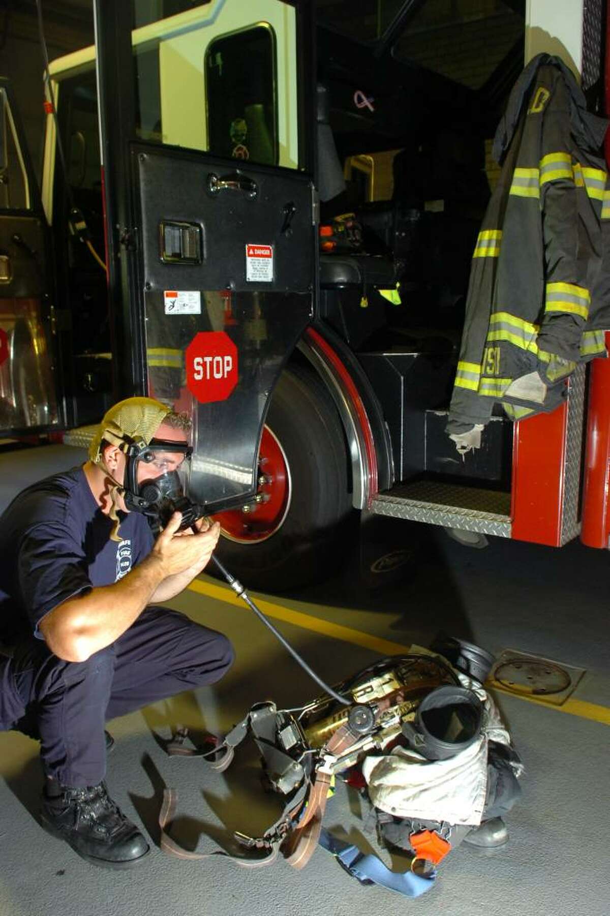 Fairfield firefighter Dennis Eannotti demonstrates how he inspects his self contained breathing apparatus, which includes a bottle of compressed air and breathing regulator.