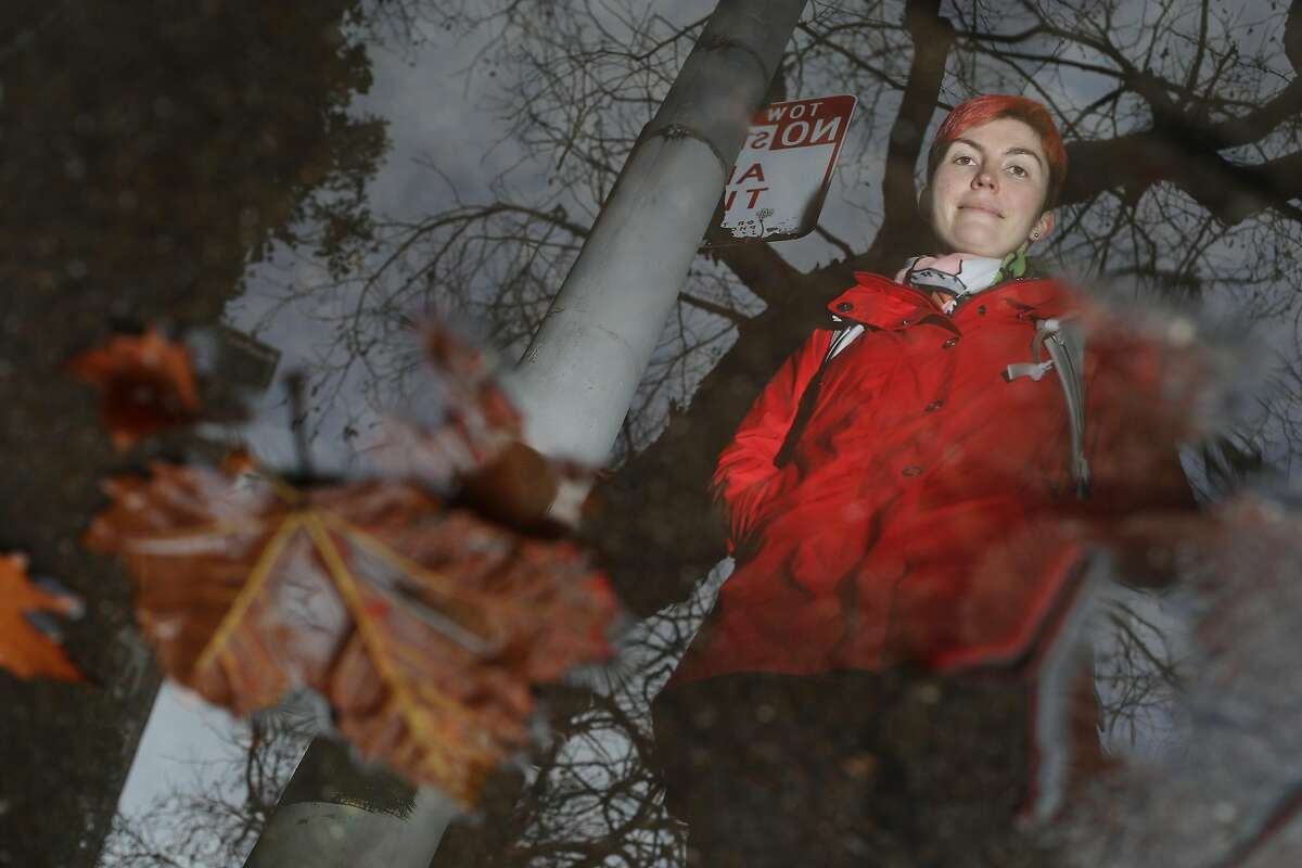 Leigh Honeywell of San Francisco is seen reflected in a puddle of water with leaves as she stands for a portrait on Battery Street on Thursday, January 17, 2019 in San Francisco, Calif. Honeywell slipped on a wet pile of leaves in 2015 on Battery Street on her way to see a show at the Punchline.