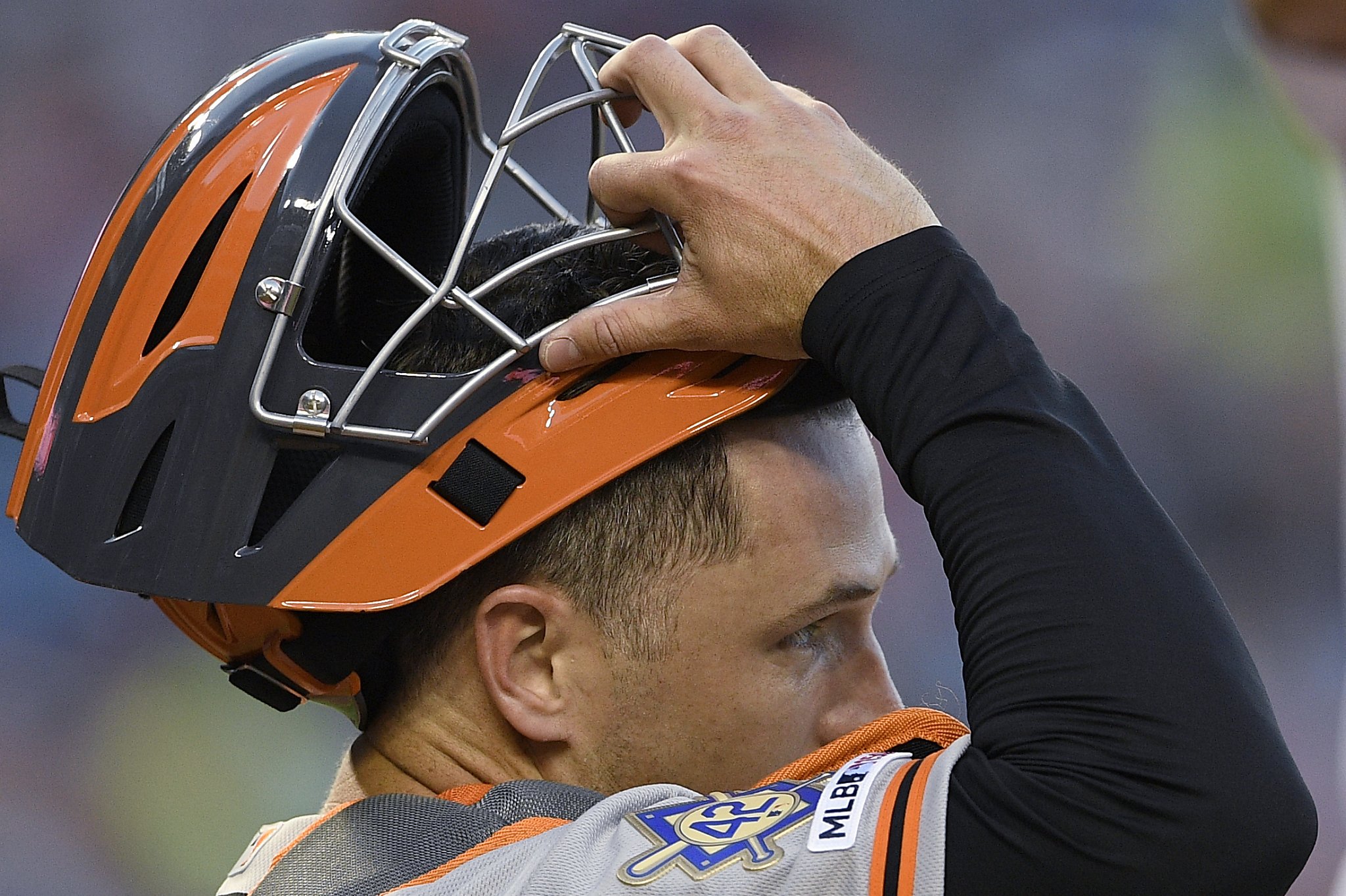 Giants' Buster Posey behind the plate again after foul tip off mask