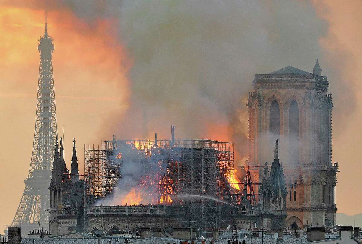 In this image made available on Tuesday April 16, 2019 flames and smoke rise from the blaze after the spire toppled over on Notre Dame cathedral in Paris, Monday, April 15, 2019. An inferno that raged through Notre Dame Cathedral for more than 12 hours destroyed its spire and its roof but spared its twin medieval bell towers, and a frantic rescue effort saved the monument's "most precious treasures," including the Crown of Thorns purportedly worn by Jesus, officials said Tuesday. (AP Photo/Thierry Mallet)