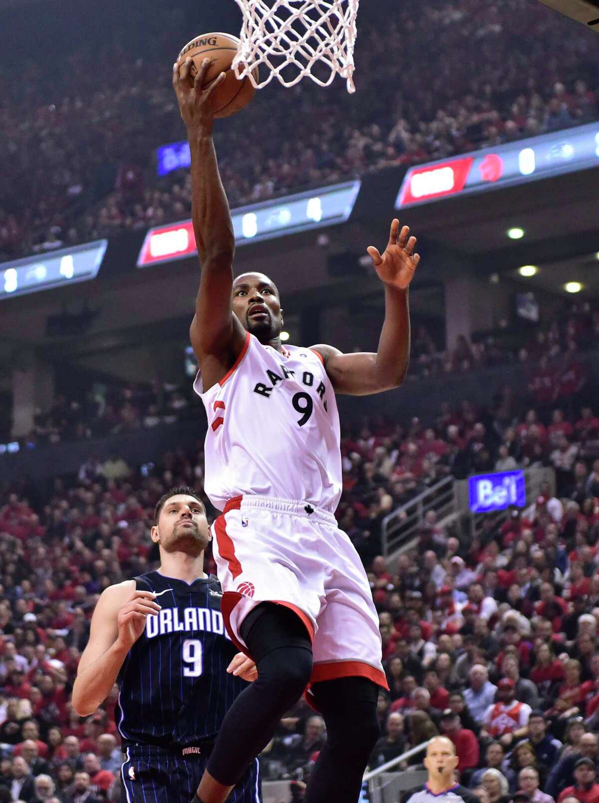 Toronto Raptors' Serge Ibaka scores as Orlando Magic centre Nikola Vucevic (9) watches during the first half of Game 2 of an NBA basketball first-round playoff series Tuesday, April 16, 2019, in Toronto. (Frank Gunn/The Canadian Press via AP)