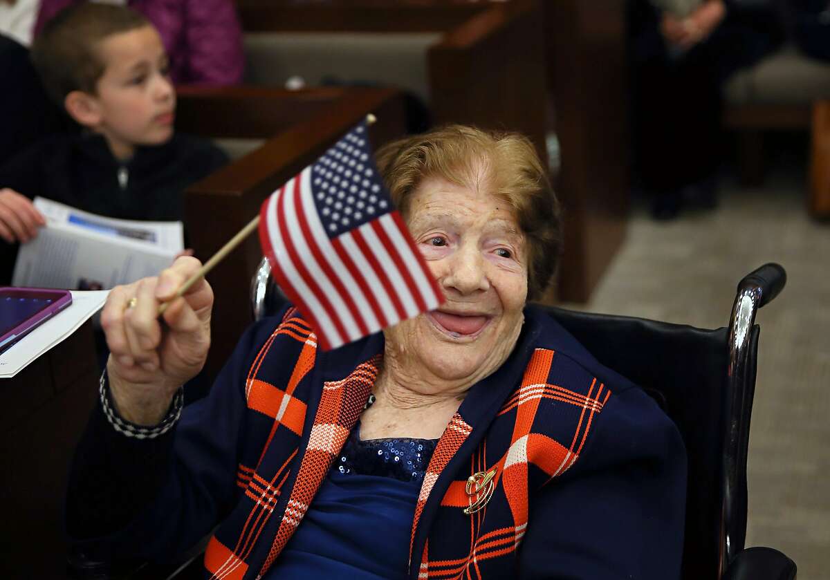 101-year-old Francesca Taullo waves an American flag before her naturalization ceremony at the Thomas F. Eagleton U.S. Courthouse, Friday, April 12, 2019 in St. Louis. Taullo immigrated from Italy to the United States by boat with her husband Joe Taullo in 1965. The family ran Giancarlo's Ristorante on Hampton Avenue in St. Louis from 1987 until they retired from the restaurant business in 2014. (David Carson/St. Louis Post-Dispatch via AP)
