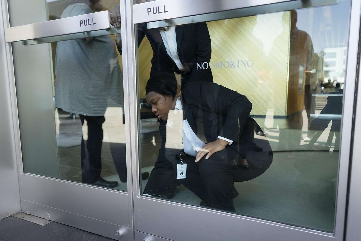 Security guards at Kaiser's headquarters lock the doors before protesters could enter in Oakland, Cailf. on Wednesday, April 17, 2019. Kaiser patients and their families protested outside asking the CEO to meet with them about providing adequate mental health care.