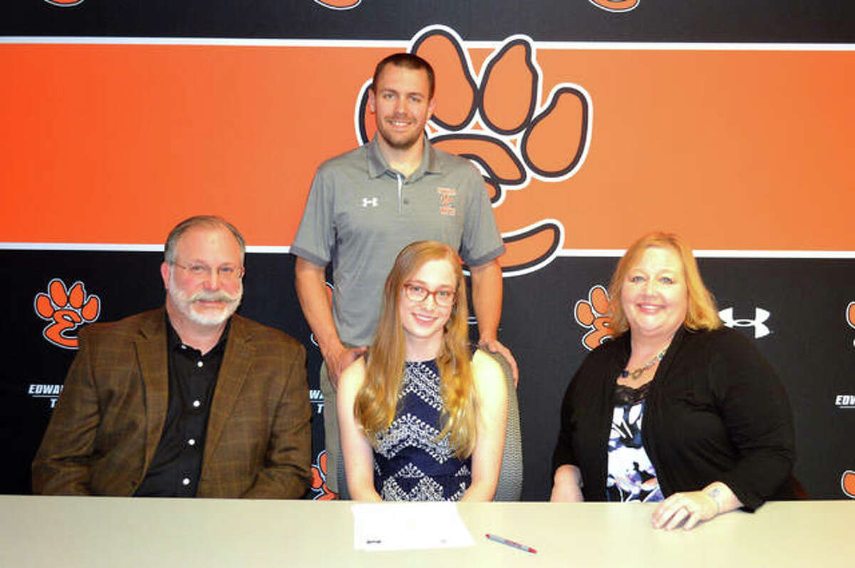 Edwardsville senior Morgan Rockwell, seated middle, signed to compete in women’s swimming and the triathlon at Millikin University in Decatur. She is joined by her parents and EHS coach Christian Rhoten.
