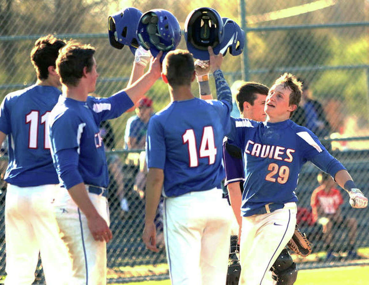 Carlinville’s Aidan Naugle (29) is greeted at the plate after his grand slam drove home Sam Tieman (11), Colton DeLong and Lonny Rosentreter in the fourth inning of the Cavaliers’ five-inning victory Tuesday at Litchfield.
