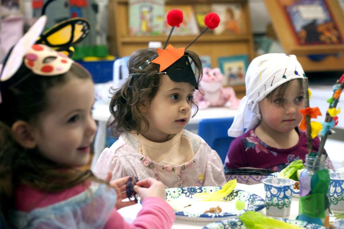From left, nursery school students Faith Meyers, Roxanne Daigle and Louisa Voisine take part in a Seder meal at Congregation B'nai Torah, in Trumbull, on April 8.