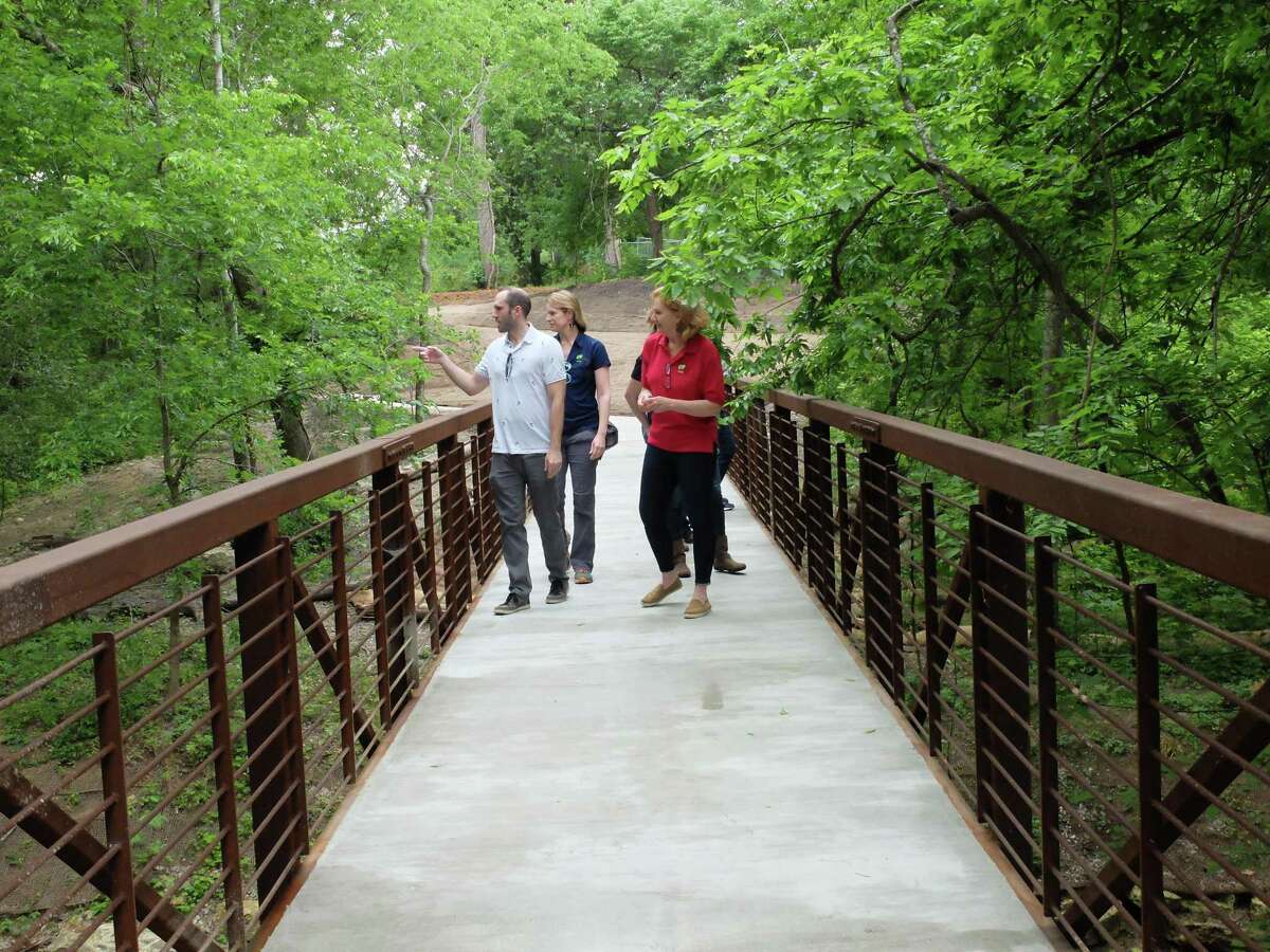 Conners Ladner of Design Workshop, from left, conservation director Emily Manderson, executive director Debbie Markey and other staff of the Houston Arboretum & Nature Center cross one of two new steel bridges across the arboretum's new ravine path.