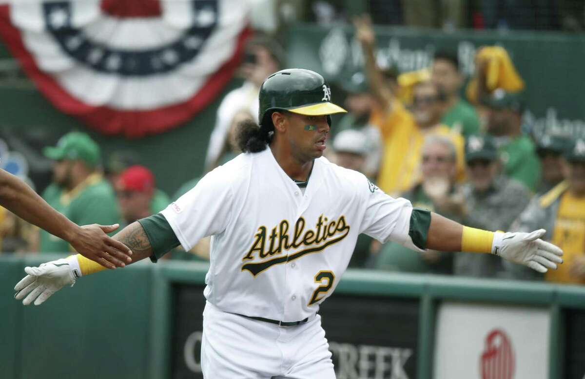 Khris Davis returns to the dugout after blasting a solo homer in the 6th inning of the Oakland A's home opener against the Los Angeles Angels in Oakland, Calif. on Thursday, March 28, 2019.