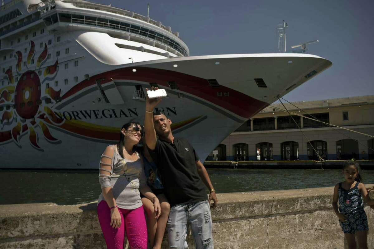 Cubans take a selfie in front of a cruise ship docked in Havana, Cuba, Wednesday, April 17, 2019. The Trump administration on Wednesday intensified its crackdown on Cuba, including restricting “non-family travel,” in a country where tourism is a key lifeline of hard currency.