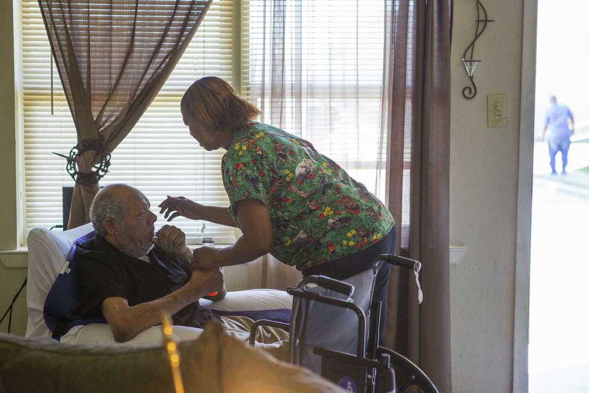 Cynthia Minix helps her husband, John Deason, who recently suffered a stroke, inside their home at the Sandpiper Cove apartments.
