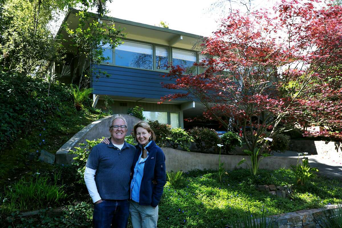 Michael and Alison Downs pose for a photo in front of their home in Berkeley, Calif., on Saturday, April 13, 2019. When the couple bought their home to be close to their kids, they didn't think they'd have any trouble getting insurance. But Michael's insurer since 1977, State Farm, refused to insure the new house, in addition to a dozen other companies. He got a policy from Travelers for more money. The insurance company also required him to switch all his coverage for his car and personal liability umbrella.