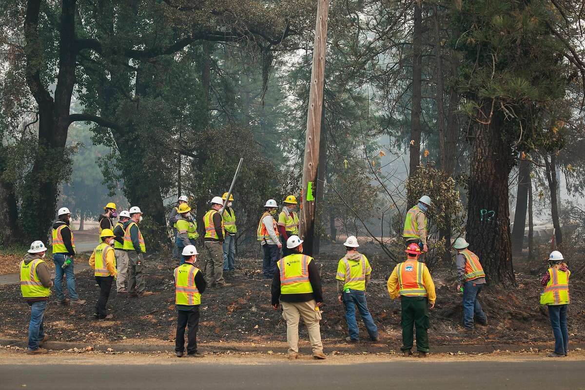 PG&E watch as trees are marked for cutting after the Camp Fire tore through the town of Paradise, California, on Wednesday, Nov. 14, 2018.