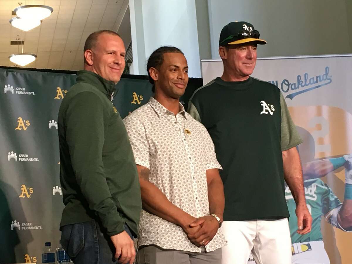 General manager David Forst, designated hitter Khris Davis and manager Bob Melvin (L to R) pose after a news conference to announce Davis' two-year extension, which will keep him in Oakland through 2021, on April 19 at the Oakland Coliseum in Oakland, Calif.