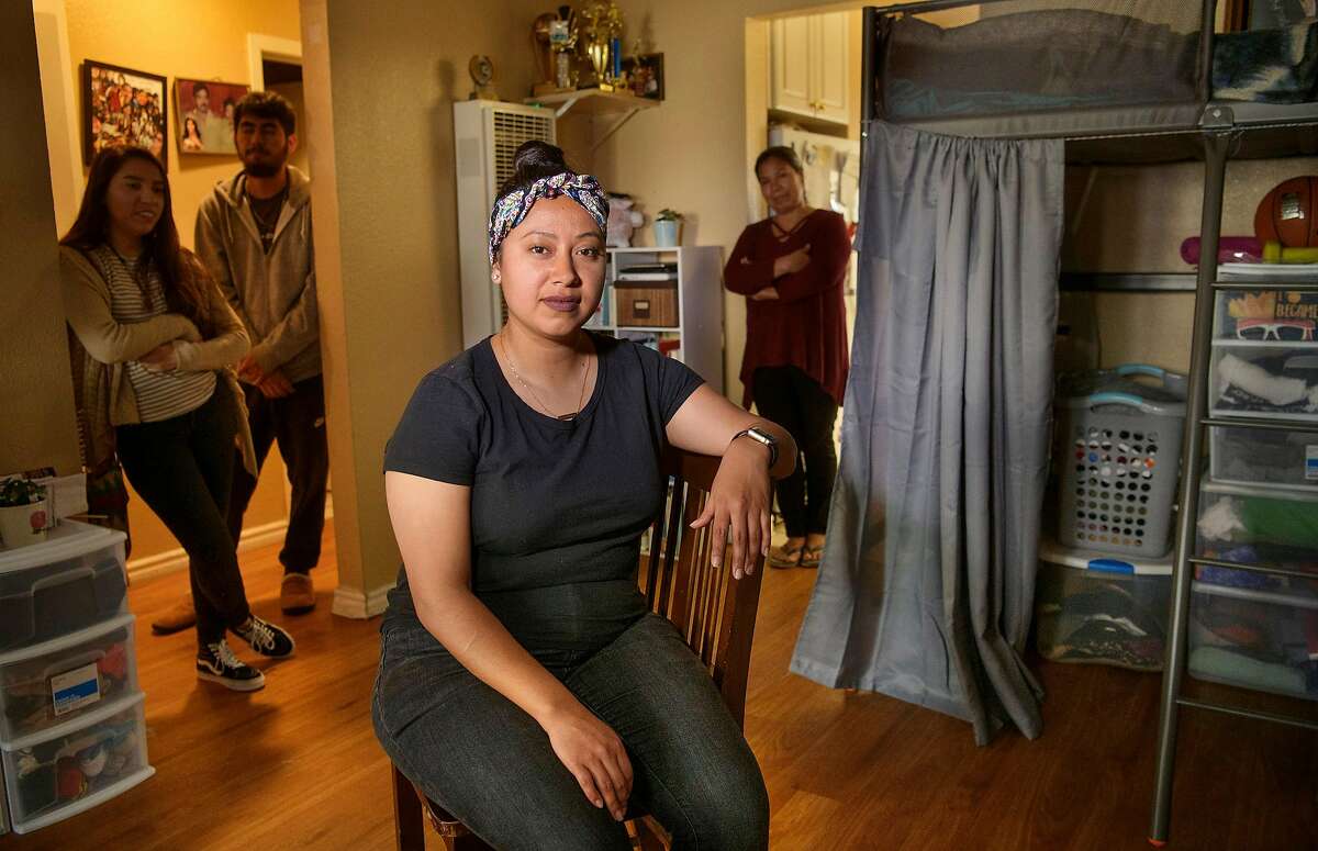 Teacher Roxana De La O Cortez, center, at her home in Hayward, Calif., Saturday, Mar. 2, 2019. Behind her are her sister Odalis De La O Cortez, left, brother Manual De La O Cortez, and their mother Antonia Cortez Garcia who all live together in the apartment.